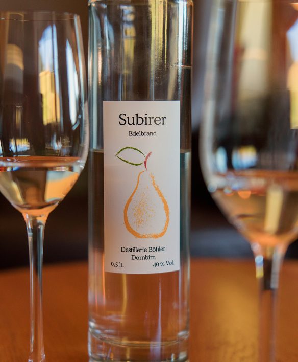 Flasche Subirer Edelbrand zwischen zwei gefüllten Gläsern an der Wälderbar, Subirer ist eine alte Vorarlberger Birnensorte und typischer Schnaps der Region.
